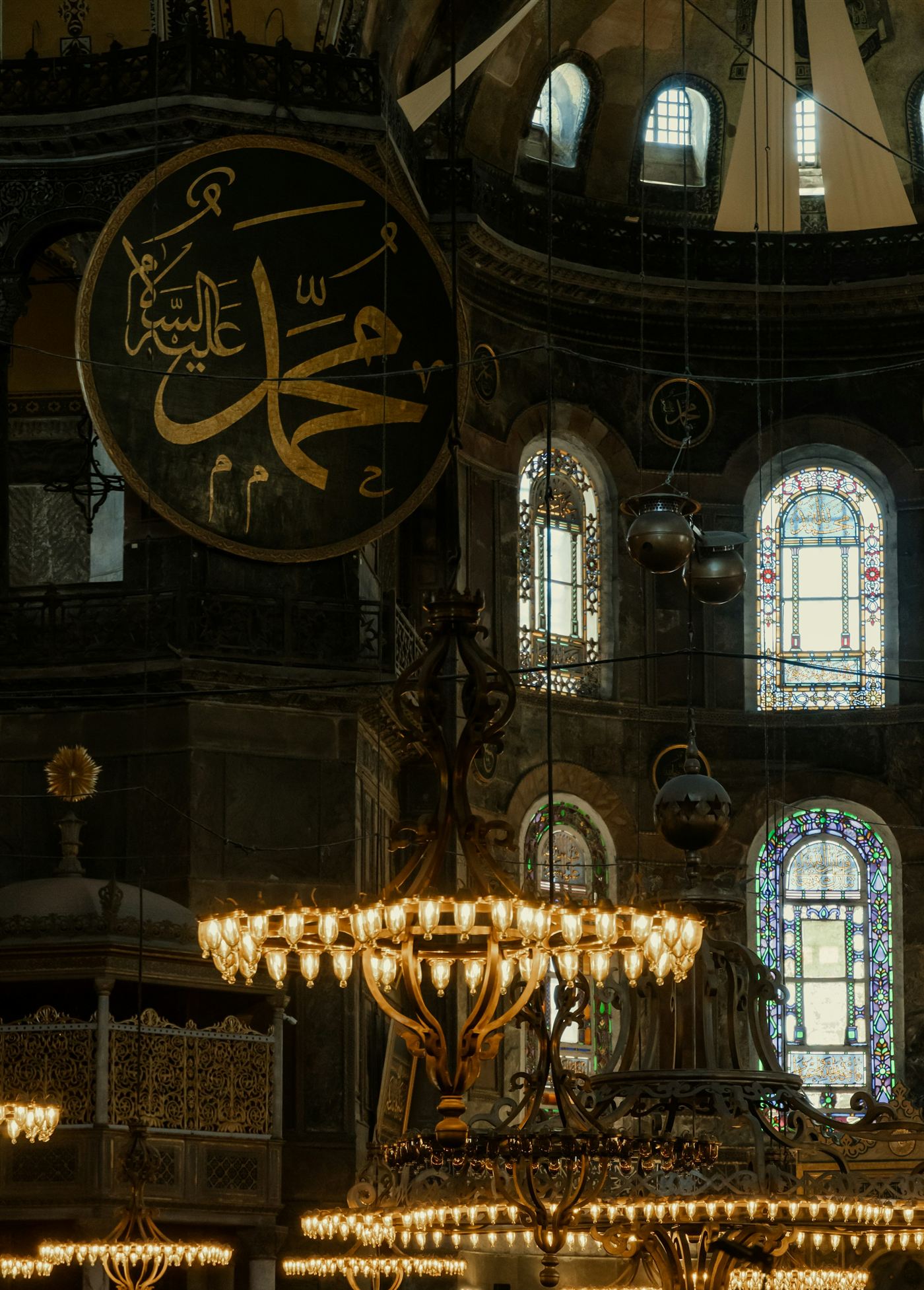 The name Muhammad in a great roundel above lit chandeliers, Hagia Sophia, Istanbul